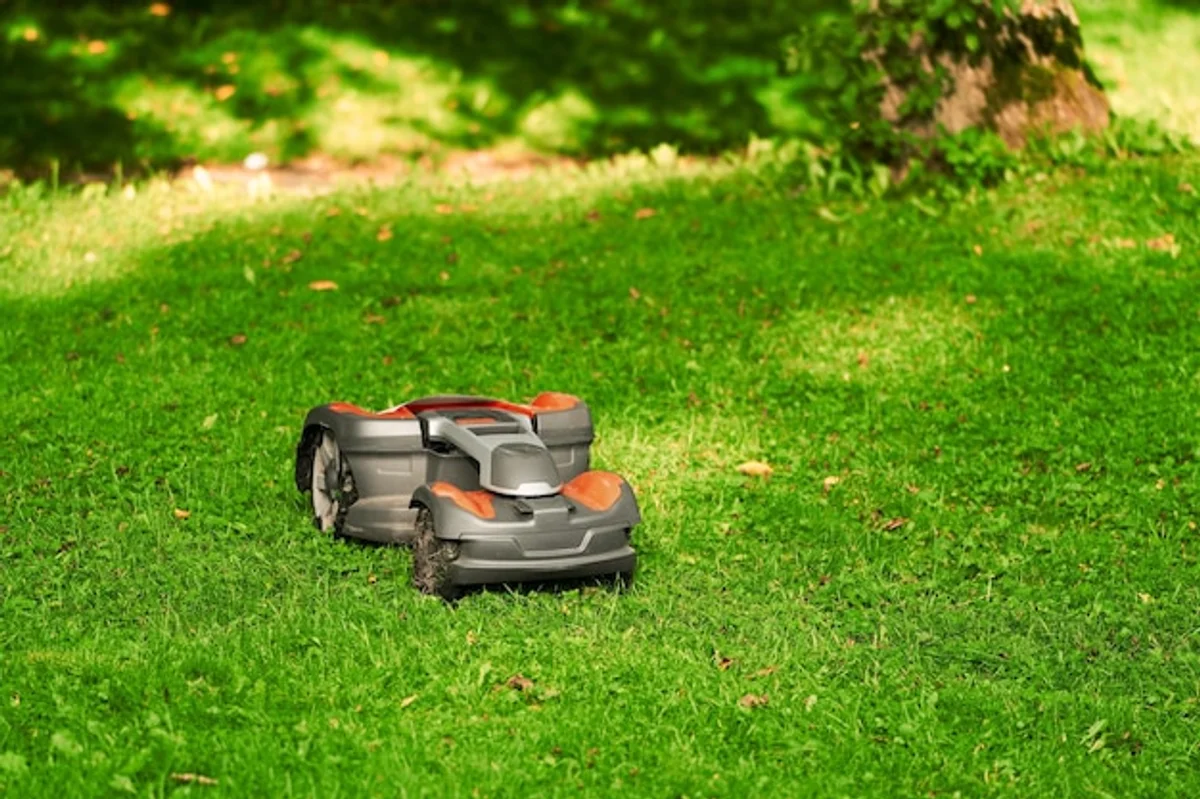 modern cordless lawn mower in action on green grass garden